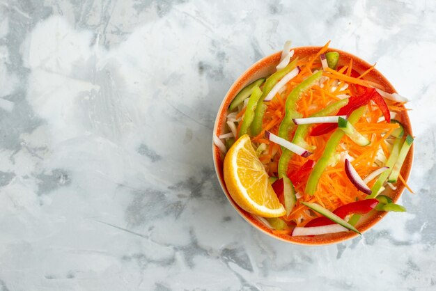 Vista superior ensalada de verduras frescas dentro del plato en la superficie blanca comida sana comida dieta cena