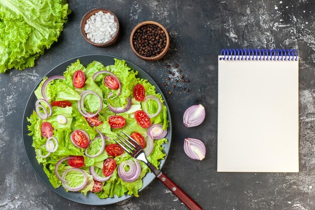Vista superior ensalada de verduras frescas con ensalada verde cebollas y tomates sobre fondo gris comida ensalada comida dieta color maduro foto de salud
