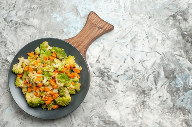 Foto gratuita vista superior de ensalada de verduras frescas y saludables en la tabla de cortar de madera en la mesa blanca