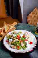 Foto gratuita una vista superior de ensalada de verduras con rodajas de pollo y pan en la mesa verde comida comida verduras