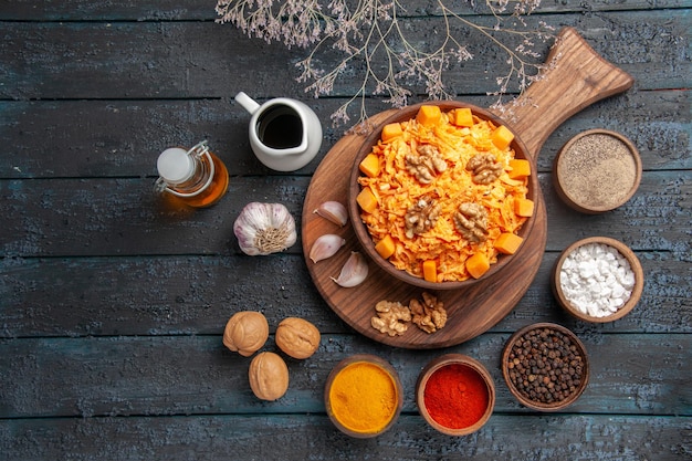 Vista superior ensalada de zanahoria fresca con nueces y condimentos en la salud de color de ensalada de dieta de nueces de escritorio azul oscuro