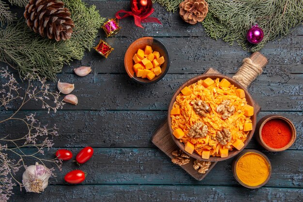 Vista superior de ensalada de zanahoria rallada con nueces y condimentos en el escritorio oscuro dieta de alimentos de color de nuez ensalada de salud