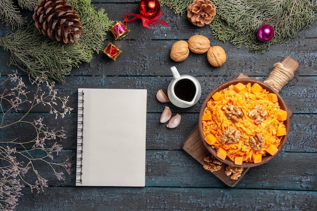 Vista superior Ensalada de zanahoria rallada con nueces en el escritorio oscuro Dieta de alimentos de color de nuez de ensalada de salud