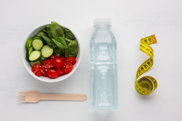 Foto gratuita vista superior de la ensaladera y la botella de agua