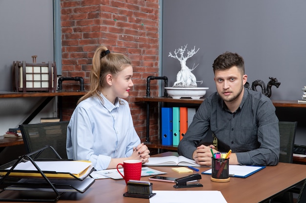 Vista superior del equipo de administración de la oficina sentado en la mesa discutiendo un tema en la oficina