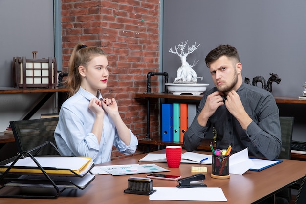 Vista superior del equipo profesional trabajador y confiado que discute un tema importante en la oficina