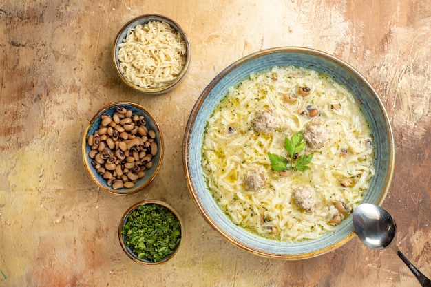 Vista superior erishte azerbaiyano en un tazón una cuchara para diferentes alimentos en tazones sobre fondo beige