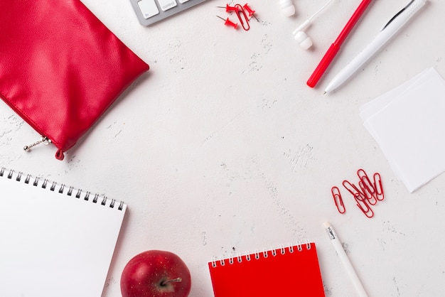 Vista superior del escritorio con manzana y papelería