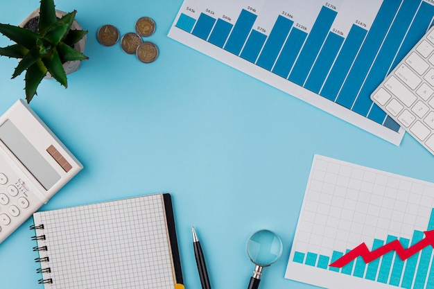 Vista superior del escritorio de oficina con tabla de crecimiento y monedas