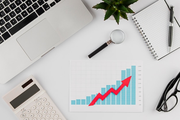 Vista superior del escritorio de oficina con tabla de crecimiento y portátil