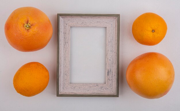 Vista superior del espacio de copia naranjas con pomelo y marco gris sobre fondo gris