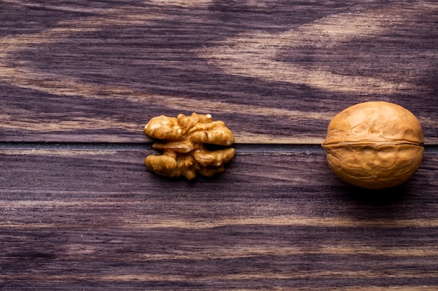 Foto gratuita vista superior espacio de copia nueces con cáscara y peladas en una mesa de madera