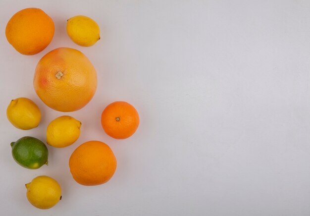 Vista superior espacio de copia pomelos con naranjas y limones sobre fondo blanco.