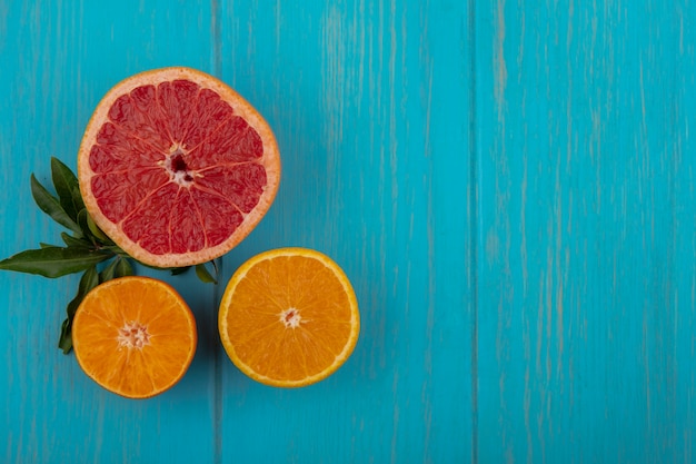 Vista superior espacio de copia rodaja de naranja con rodaja de pomelo sobre fondo turquesa