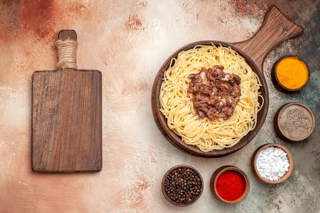 Vista superior de espaguetis cocidos con carne molida en un plato de mesa ligera carne de pasta