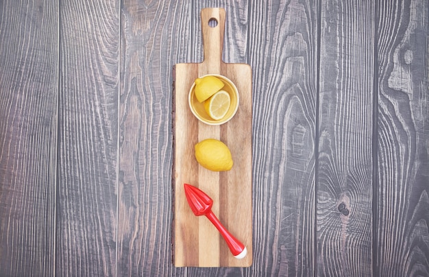 Foto gratuita vista superior del exprimidor de limón y limón sobre tabla de madera