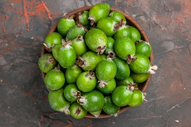 Vista superior de feijoas frescas de bomba de vitamina pequeña verde en una olla marrón