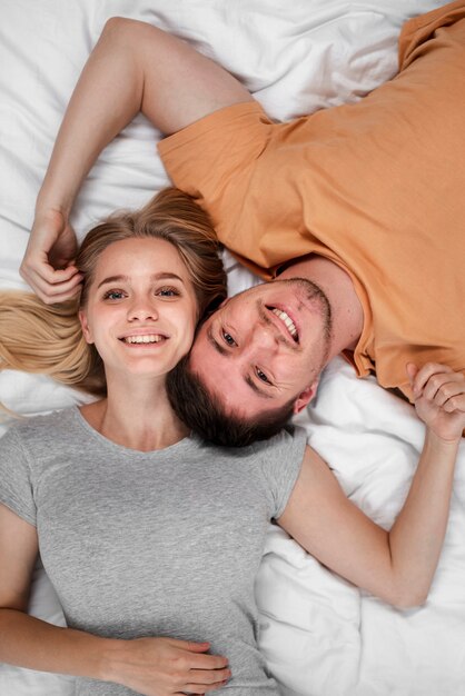 Vista superior feliz pareja acostado en la cama