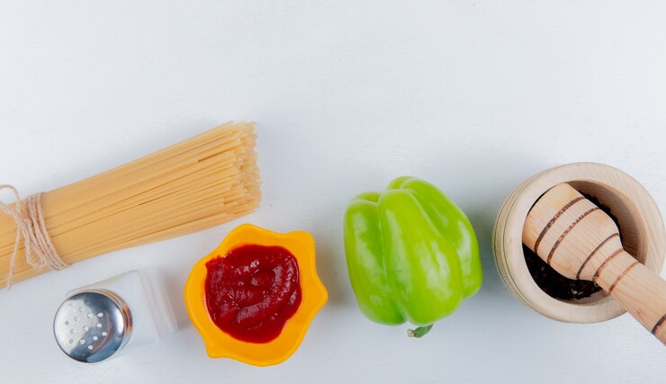 Foto gratuito vista superior de fideos macarrones con salsa de tomate pimienta negra sobre blanco