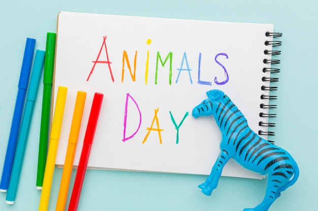 Foto gratuita vista superior de la figura de cebra y escritura colorida en el cuaderno para el día de los animales