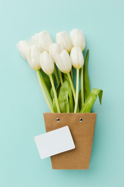 Vista superior de flores blancas de tulipán en una linda maceta de papel