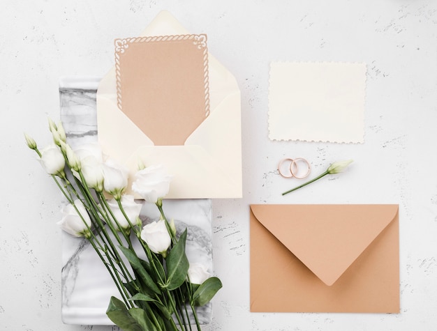 Vista superior de flores con tarjetas de invitación de boda