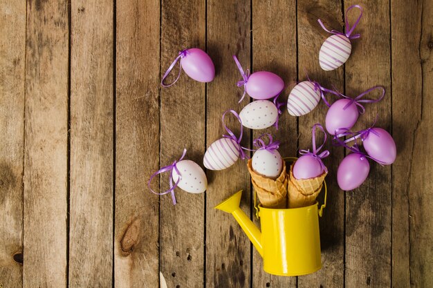 Vista superior de fondo de madera con regadera y huevos de pascua