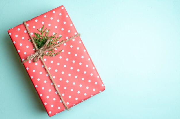 Vista superior del fondo de Navidad con caja de regalo en el lado derecho sobre fondo verde pastel