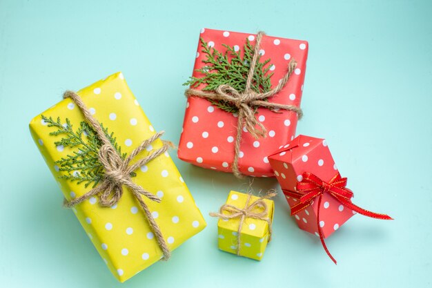 Vista superior del fondo de Navidad con cajas de regalo amarillas y rojas sobre fondo verde pastel