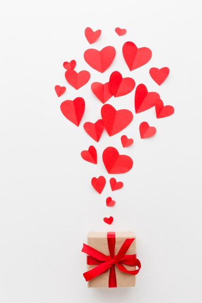 Vista superior de formas de corazón de papel y regalo para el día de San Valentín
