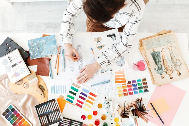 Vista superior foto recortada de mujer joven ilustrador de moda dibujo