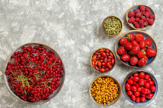 Vista superior de fresas frescas con arándanos sobre un fondo blanco.