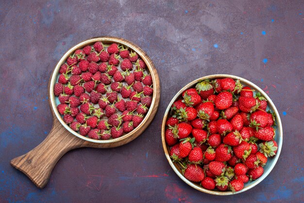 Vista superior de fresas rojas frescas frutas suaves con frambuesas en la superficie azul oscuro baya comida suave de verano