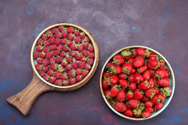 Vista superior de fresas rojas frescas frutas suaves con frambuesas en la superficie azul oscuro baya comida suave de verano