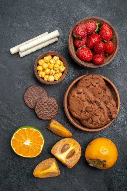 Vista superior de fresas rojas frescas con galletas dulces en la mesa oscura galleta de azúcar fresca