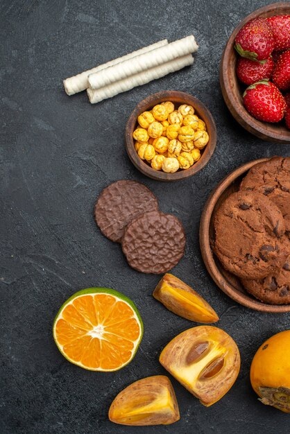 Vista superior de fresas rojas frescas con galletas en la mesa oscura galleta de azúcar dulce