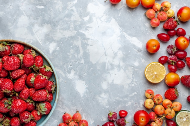 Vista superior de fresas rojas frescas con otras frutas en la mesa de luz, fruta, baya, vitamina fresca