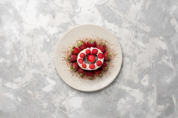 Vista superior de fresas rojas frescas con pastel en un espacio en blanco