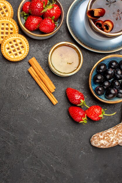 Vista superior de fresas rojas frescas con té y aceitunas en el piso oscuro baya de fruta fresca