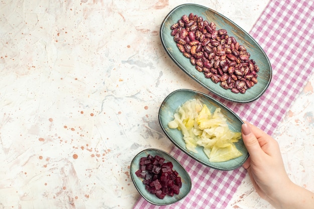 Vista superior de frijoles en escabeche, repollo cortado remolacha en placas ovaladas