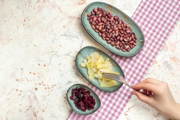 Vista superior de frijoles en escabeche, repollo cortado remolacha en placas ovaladas