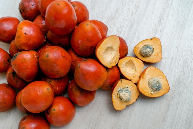 Foto gratuita vista superior de frutas de chontaduro enteras y cortadas a la mitad en la mesa de madera