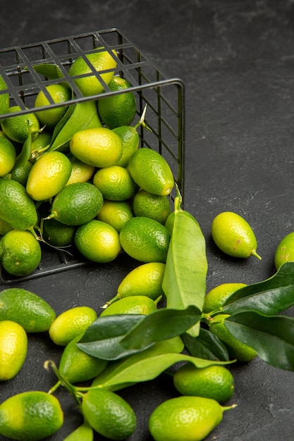 Vista superior de frutas cítricas frutas cítricas en la canasta sobre la mesa oscura