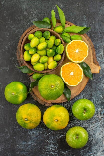 Vista superior de frutas cítricas frutas cítricas con hojas en la tabla de cortar