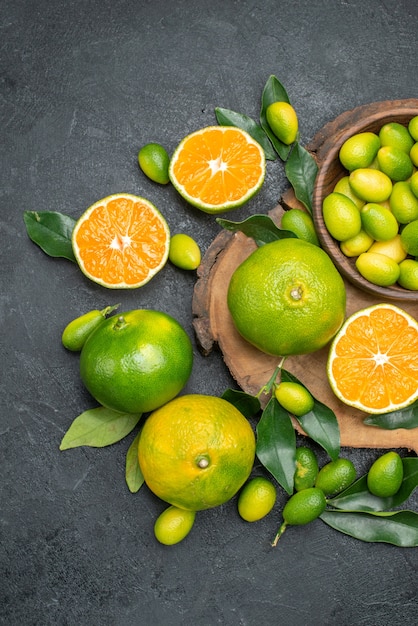 Vista superior frutas cítricos mandarinas con hojas en el tablero