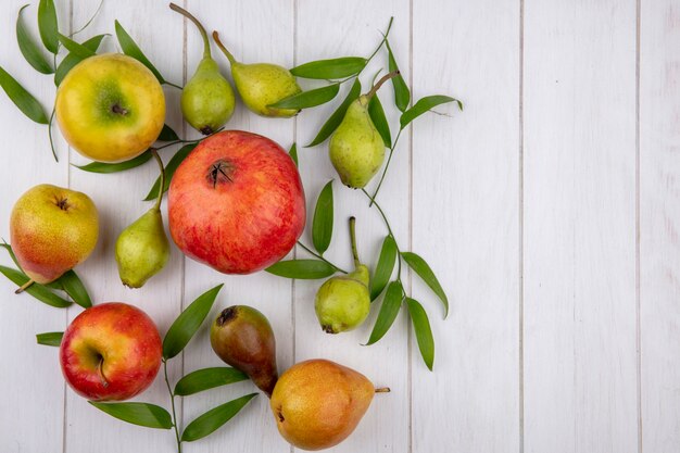 Vista superior de frutas como durazno granada manzana sobre superficie de madera