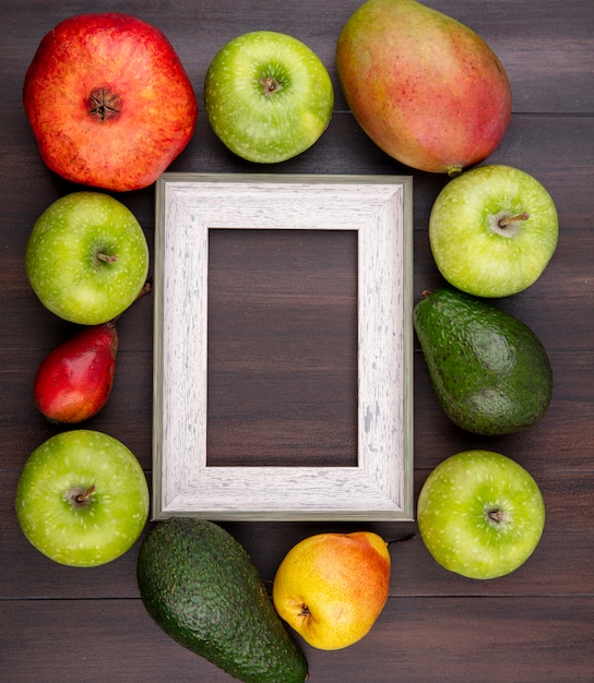 Vista superior de frutas frescas y deliciosas como manzana, granada, pera en madera con espacio de copia