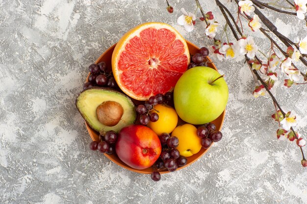 Vista superior de frutas frescas dentro de la placa sobre superficie blanca