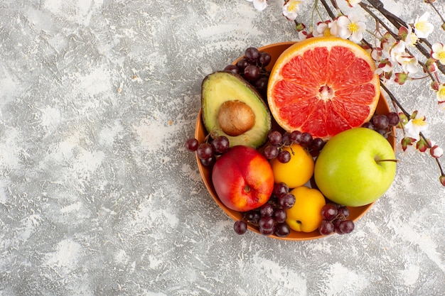 Vista superior de frutas frescas dentro de la placa sobre superficie blanca