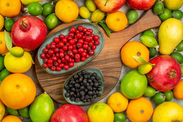 Vista superior de frutas frescas diferentes frutas maduras y suaves en el escritorio blanco